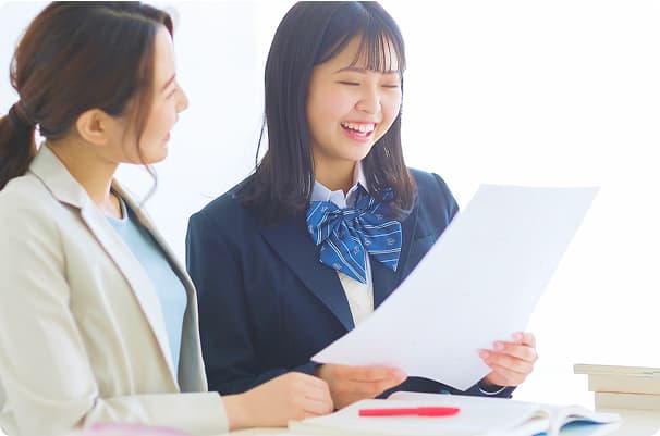 笑顔でプリントを見る生徒と講師